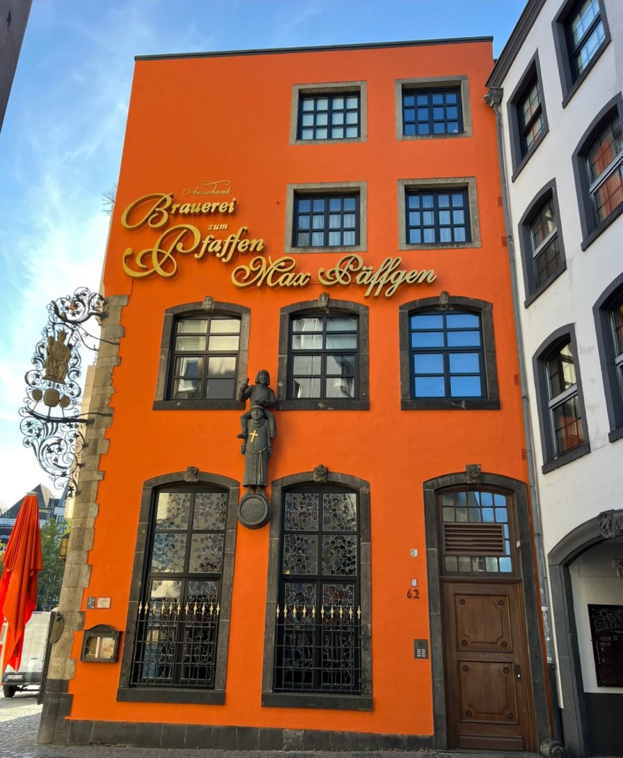 Orangefarbene Fassade der Brauerei zum Pfaffen am Kölner Heumarkt